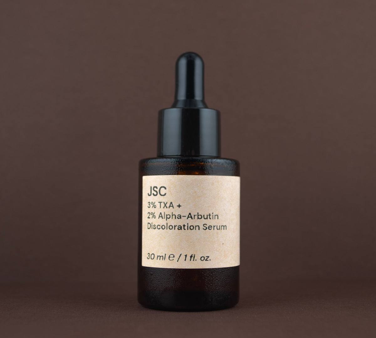 Front view of JSC 3% TXA + 2% Alpha-Arbutin Discoloration Serum (30 ml / 1 fl. oz.) in an amber glass dropper bottle.