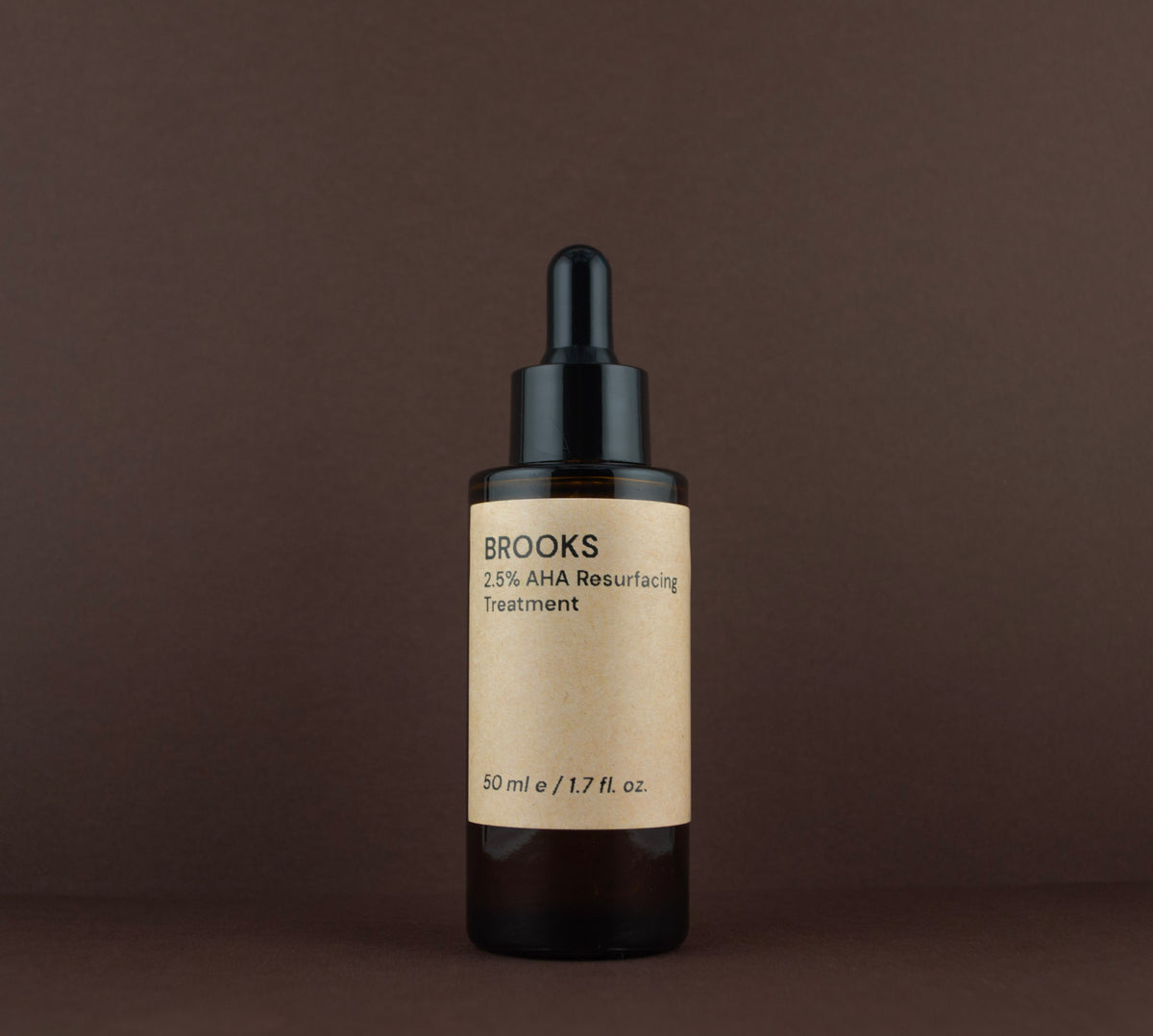 Front view of Brooks 2.5% AHA Resurfacing Treatment (50 ml / 1.7 fl. oz.) in an amber glass dropper bottle.