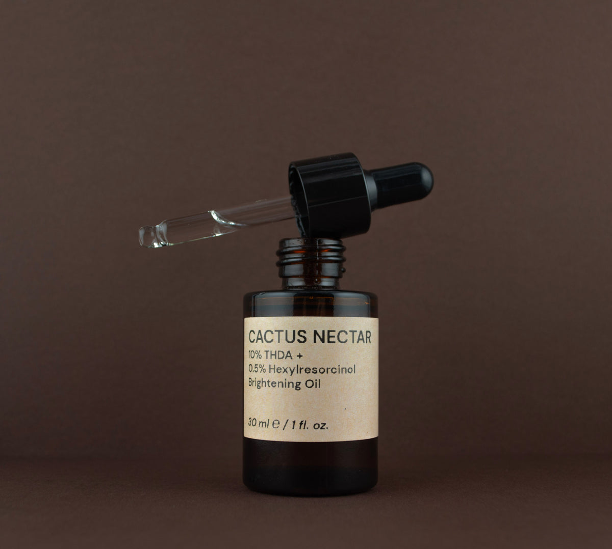 Open bottle of Cactus Nectar Vitamin C brightening oil showing the glass dropper pipette resting on the rim.