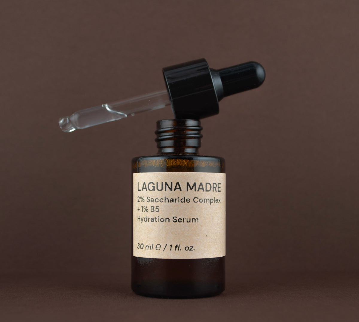 Open bottle of Laguna Madre hydration and plumping serum showing the glass dropper pipette resting on the rim.