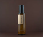 Side view of the Seven Regions amber glass cleanser pump bottle.