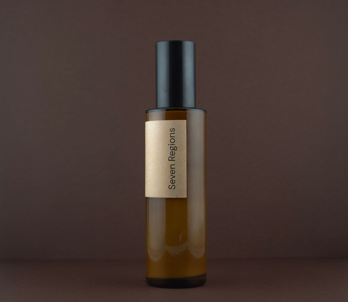 Side view of the Seven Regions amber glass cleanser pump bottle.